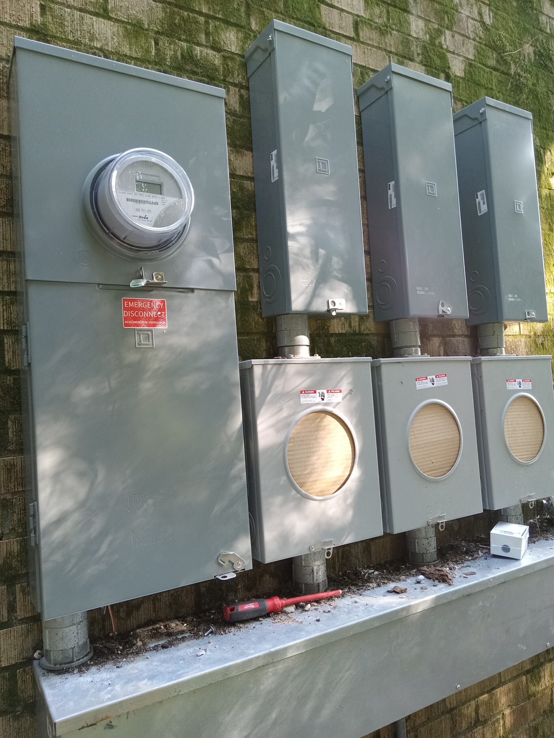 Five electrical meter boxes mounted on a wall, with a single meter on the leftmost box. A 